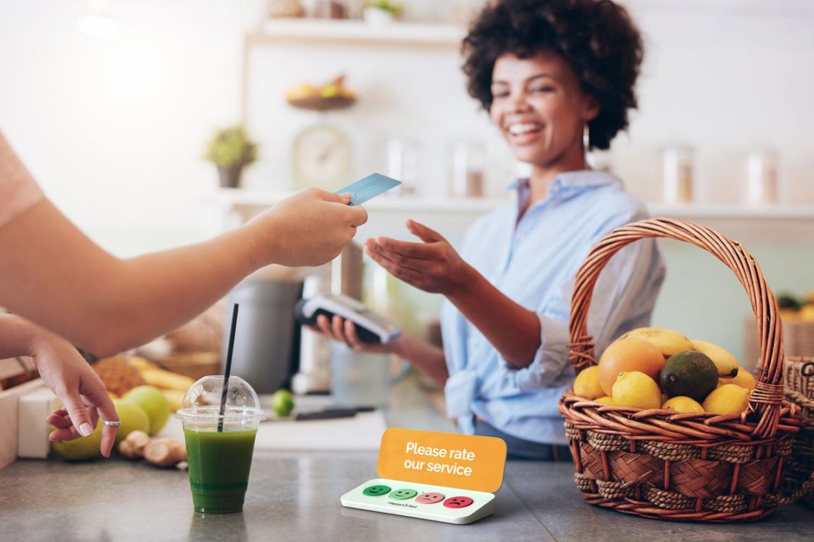 A happy woman selling a smoothie.