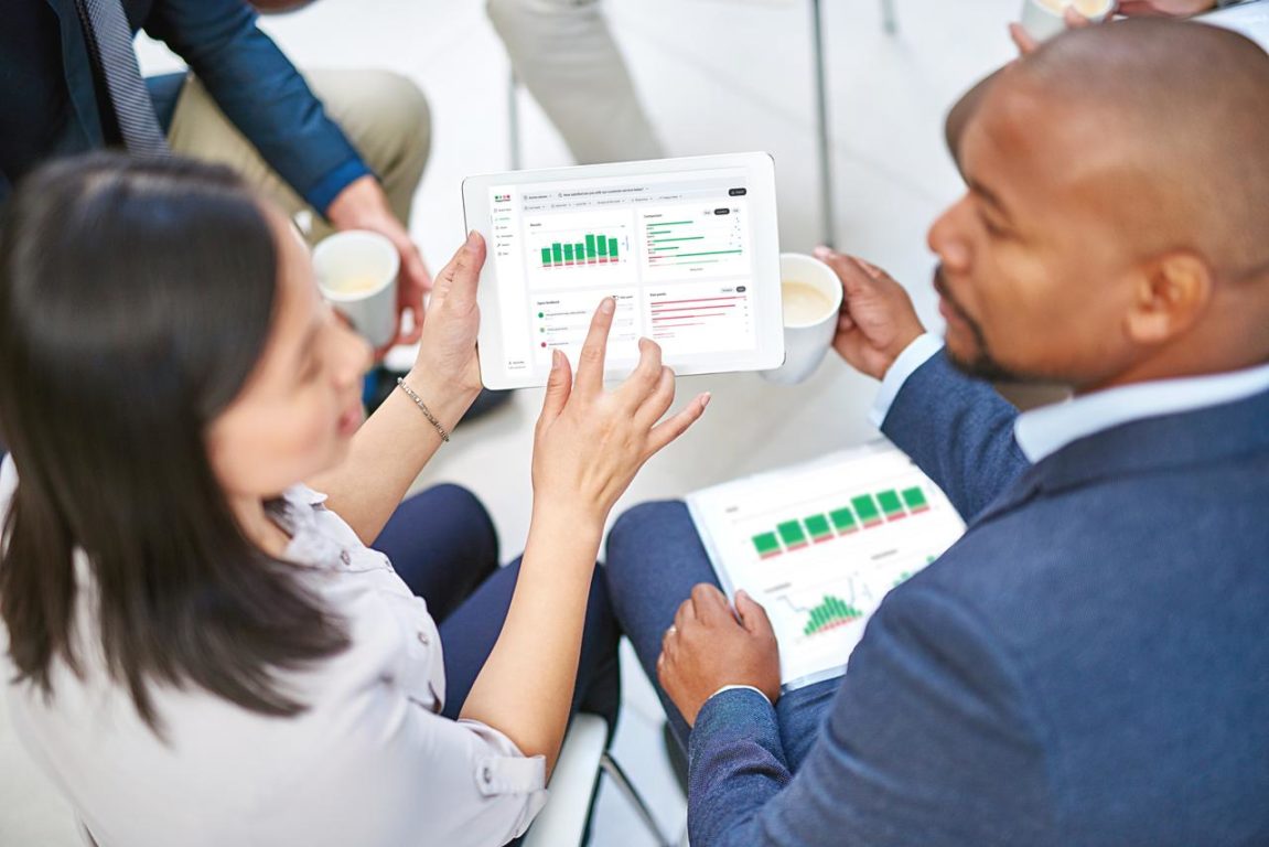 A man and a woman looking at a graph.